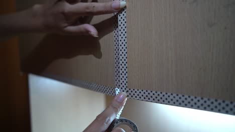 Hands-Decorating-Wooden-Cabinet-Doors-With-Washi-Tape-Decor---close-up
