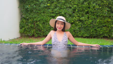 Sexy-asian-model-relaxing-in-a-pool-smiling
