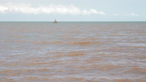 Lonely-african-fisherman-in-his-small-boat-sailing-in-muddy-ocean-from-nearby-river