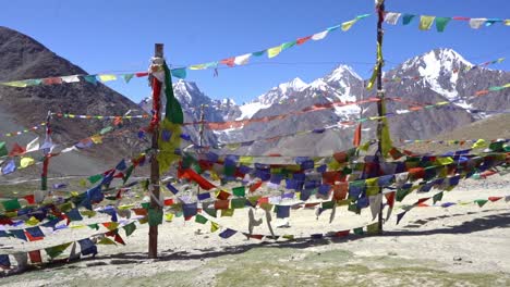 Buddhist-Prayer-Flags-Blow-By-The-Wind-With-Mountains-In-Background---wide-shot