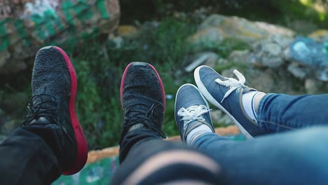adventure-couple-dangle-and-hang-their-feet-and-legs-off-the-side-of-a-cliff-daringly