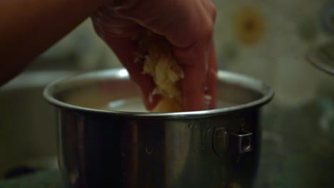 Close-Up-Of-A-Person's-Hand-Cleaning-Rice-Grains-In-A-Stainless-Pot-With-Water