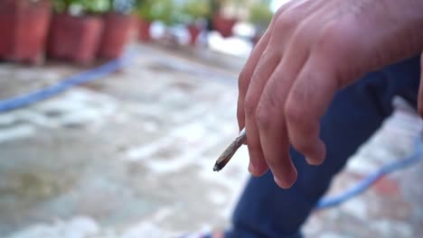 Hombre-Indio-Fumando-Mientras-La-Mano-Temblaba-Con-Su-Cigarrillo-En-Agra-India---Cerrar