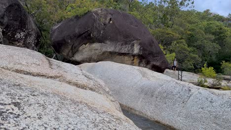 Adult-Male-Walking-Barefoot-and-Carefully-Jumping-Across-Boulder-At-Emerald-Falls-Creek