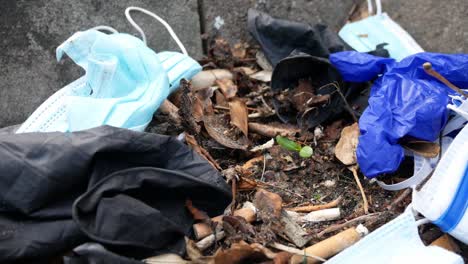Dirty-disposable-corona-virus-face-masks-and-latex-gloves-among-cigarette-rubbish-on-street-curb