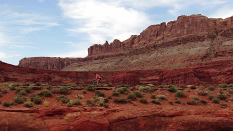Aerial-truck-left-shot-of-woman-riding-mountain-bike-in-Moab-sandstone-desert