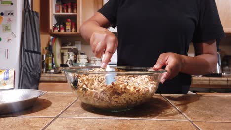 African-American-woman-mixing-ingredients-for-homemade,-organic-granola-with-a-spatula