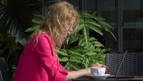 Blond-hair-woman-working-with-her-laptop-outside-office