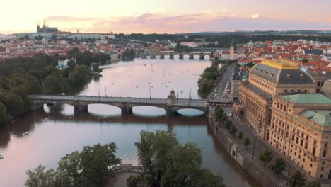 Aerial-drone-view-of-Prague-sunset-over-Vltava-river-and-Prague-castle,-St-vitus-cathedral-in-the-background