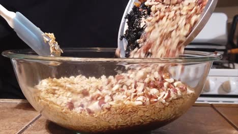 Adding-natural,-organic-dried-fruit-and-other-ingredients-to-homemade-granola---isolated