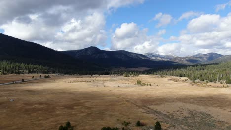 Langsamer-Sockel-über-Die-Schöne-Aussicht-Auf-Den-Tahoe-Nationalpark,-Mit-Endlosen-Offenen-Feldern-Und-Schneebedeckten-Bergen-Im-Hintergrund,-An-Einem-Hellen-Und-Etwas-Bewölkten-Tag