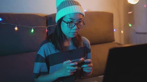 Very-concentrated-Asian-woman-playing-video-games-on-a-laptop