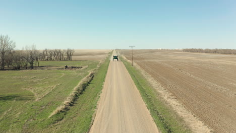 Traktorspritze,-Die-An-Einem-Sonnigen-Tag-In-Saskatchewan,-Kanada,-Auf-Der-Unbefestigten-Straße-Neben-Den-Landwirtschaftlichen-Flächen-Fährt