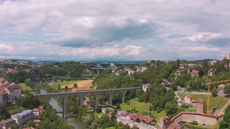 Aerial-of-charming-Fribourg-with-Zahringen-Bridge-crossing-Saane-river-in-green-valley