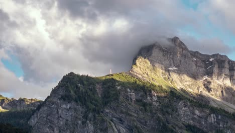 Time-lapse,-dramatic-clouds-collide-against-a-rocky-peak-in-Alps-during-sundown