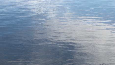 Ein-Reflektierender-Seehintergrund-Mit-Weißen-Wolken,-Die-Blaues-Wasser-Reflektieren