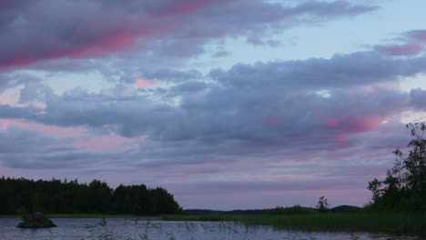 Time-lapse-of-colorful-moving-clouds-over-a-lake-by-golden-hour