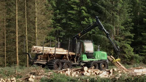 Forestry-forwarder-loading-timber-during-forestry-operations,-Highlands,-Scotland