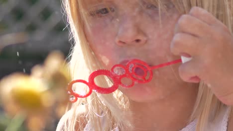 Young-girl-blows-bubbles-with-wand