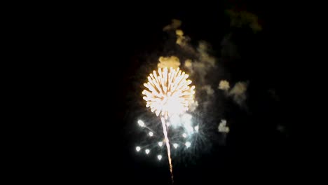 Fireworks-explode-out-of-the-red,-gold,-and-blue-smoke