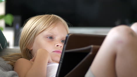Junges-Mädchen-Auf-Der-Couch-Zu-Hause,-Das-Ein-Digitales-Tablet-Gerät-Anschaut