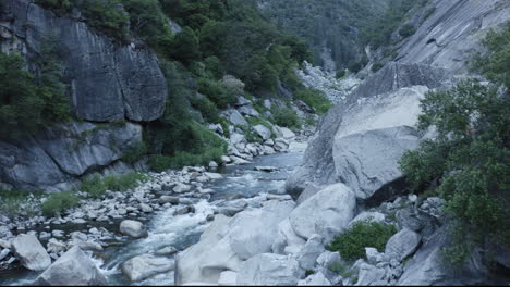 Mountain-Stream-Creek-Flows-Through-Wild-Rocky-Grey-Alpine-Valley-Landscape