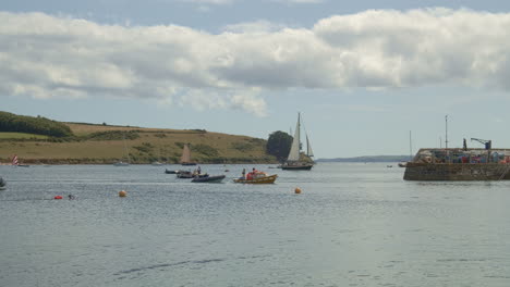 Boats-and-swimmers-pass-near-entry-to-St-Mawes-port-on-sunny-day