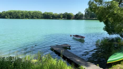 Statische-Aufnahme-Einer-Wunderschönen-Landschaft-Mit-Natürlichem-See-Im-Sommer-Und-Einsamem-Boot-Während-Covid19