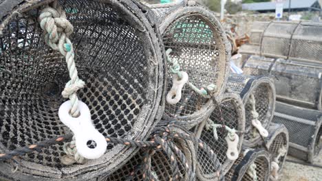 Fishing-harbour-stacked-lobster-pots-outside-coastal-marine-waterfront-dolly-left