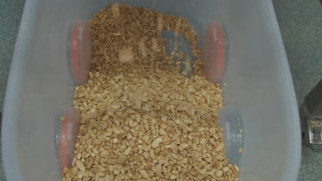 Crushed-almonds-falling-into-a-bin-at-a-factory