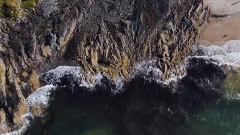 4K-birds-eye-view-of-coastal-waves-crashing-on-rocks,-slow-motion