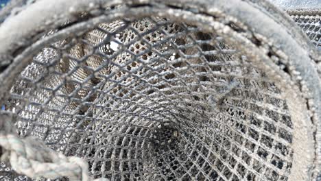 Inside-lobster-pot-on-coastal-marine-waterfront-push-in-close-up-to-netting