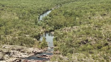 Flying-over-Australian-Outback,-waterfall-and-river-steam