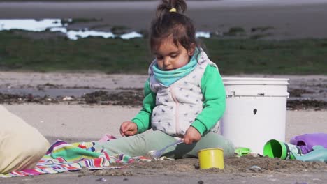 Ein-Süßes-Mädchen-Spielt-Mit-Ihren-Spielsachen-Am-Strand,-Zeitlupe