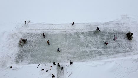 1-8-Aerial-winter-pickup-hockey-game-on-a-frozen-lake-covered-in-snow-with-amatuer-players-from-teens-to-adults