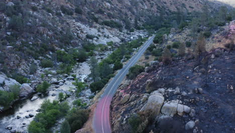 Wildfire-fire-retardant-dropped-over-mountain-valley-road,-disaster-prevention