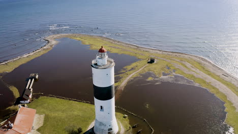 Aerial-footage-of-historic-lighthouse-Tall-John-pier-on-Öland,-Sweden-in-Baltic-sea-built-by-Russian-war-prisoners-on-south-cape-island-flooded-water-surrounding-old-building-tourist-attraction