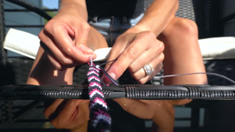 Woman-working-on-braiding-a-friendship-bracelet,-closeup