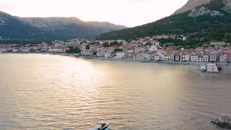 Speed-Boat-Sailing-Towards-The-Beautiful-Resort-Town-During-Sunset-Time-In-Baska,-Krk-Island-In-Croatia