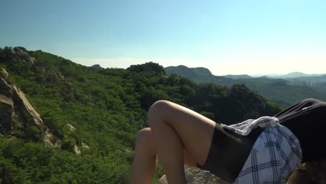Active-Lady-Hiker-Drowsing-On-The-Rocks-At-The-Mountain-Peak-Of-Gwanaksan-In-Seoul-On-A-Bright-Weather---trucking-shot
