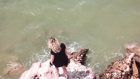 Woman-standing-on-cliff-edge-admiring-stunning-ocean-water-Darwin