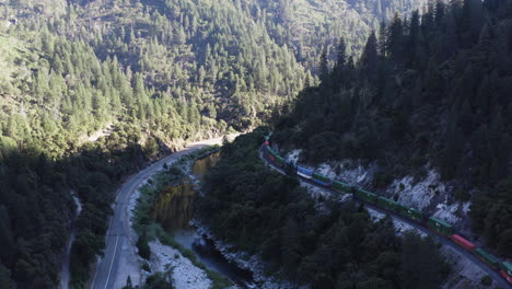 Cargo-train-of-Union-Pacific-Railroad-company-travels-through-canyon-in-mountains,-curvy-railroad,-aerial
