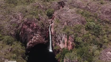 Drone-footage-flying-over-tall-waterfall-and-lake-in-Kakadu-National-Park