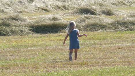 Young-girl-walks-through-freshly-harvested-field