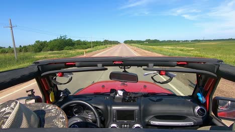 POV-Driving-on-a-paved-road-in-rural-South-Dakota,-viewing-trees,-farms-and-fields