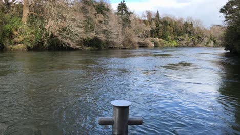 Waikato-River-flowing-gently-passed-the-boat-anchor-capstan-on-a-bright-day-in-Hamilton-New-Zealand