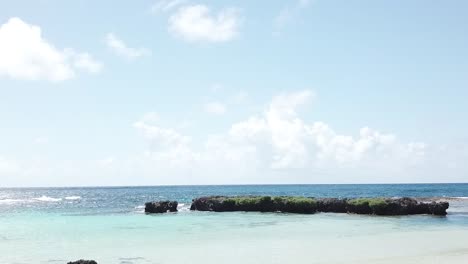 Drone-flying-between-beach-shacks-towards-stunning-Vanuatu-beach-with-clear-blue-water