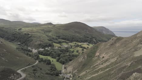 Capelulo-Penmaenmawr-Welsh-mountain-coastal-valley-aerial-pan-left-over-ridge-view-north-wales