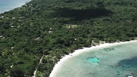 Flying-high-over-Vanuatu-village-island-beach-view-of-hills-in-background