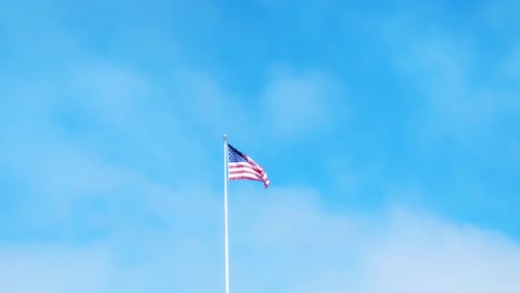 United-States-Flag-flying-in-the-wind-clouds-moving-in-background